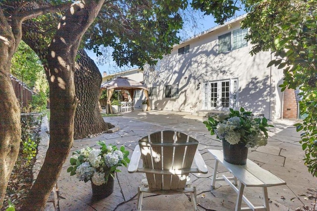 rear view of property with a gazebo, a patio area, and french doors