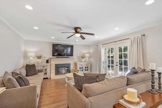 living room featuring hardwood / wood-style flooring, ornamental molding, a fireplace, and french doors