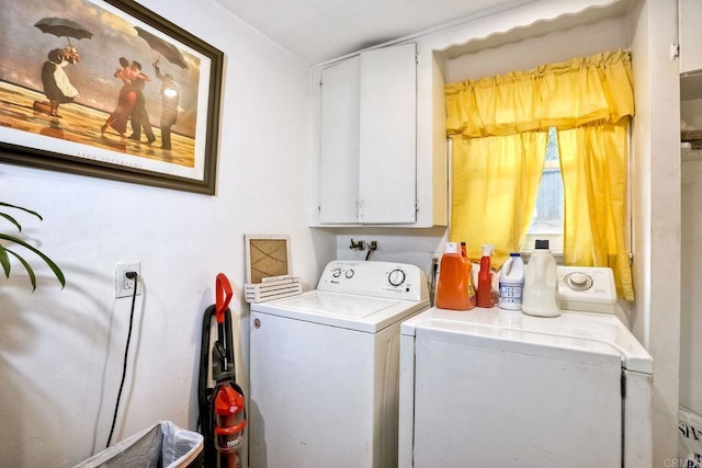 clothes washing area featuring cabinets and washer and dryer