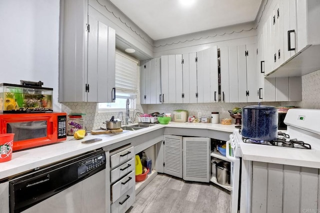 kitchen with sink, light wood-type flooring, stainless steel dishwasher, white range with gas cooktop, and decorative backsplash