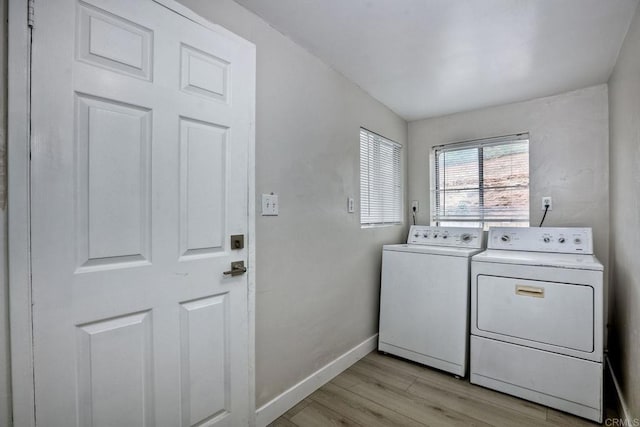 clothes washing area with light wood-type flooring and washer and clothes dryer