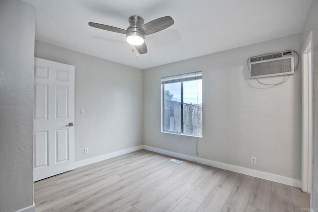 unfurnished room featuring ceiling fan, a wall unit AC, and light wood-type flooring