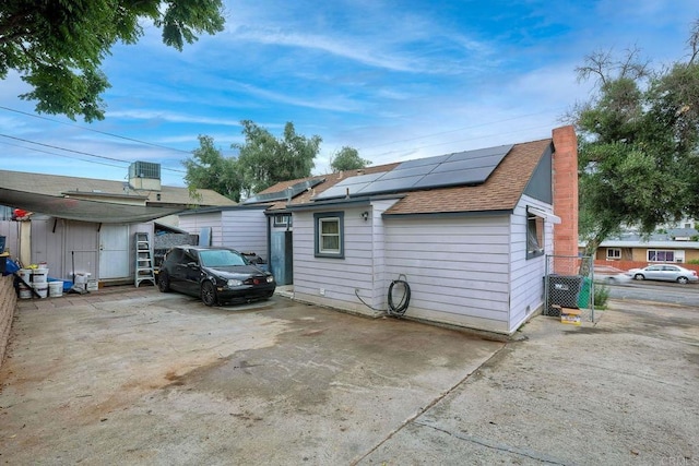 111416 N 1st St, El Cajon, CA 92021 - view of property exterior with roof mounted solar panels, roof with shingles, and a chimney