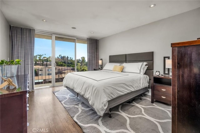 bedroom featuring floor to ceiling windows, access to exterior, and light wood-type flooring