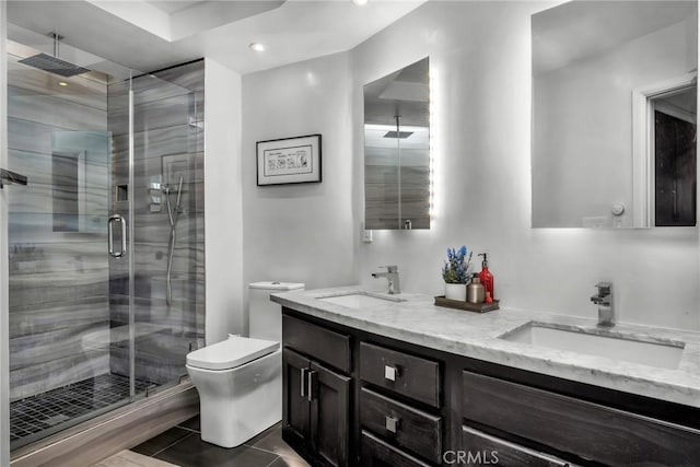 bathroom featuring vanity, a shower with shower door, and toilet