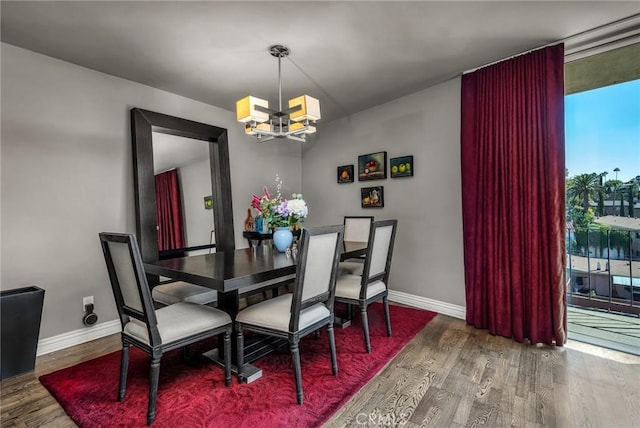 dining space featuring hardwood / wood-style flooring and a chandelier