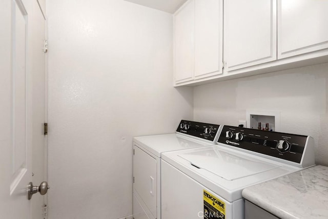 laundry area with washer and clothes dryer and cabinets