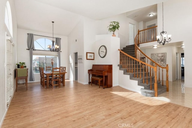 interior space with light hardwood / wood-style flooring, high vaulted ceiling, and a chandelier