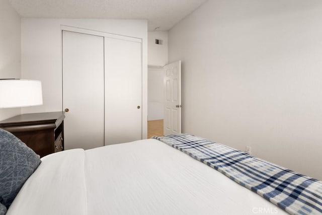 bedroom with vaulted ceiling and a closet