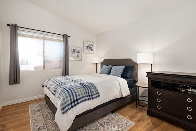 bedroom featuring vaulted ceiling and light hardwood / wood-style floors