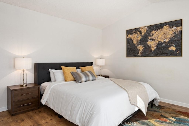 bedroom featuring lofted ceiling and dark hardwood / wood-style flooring