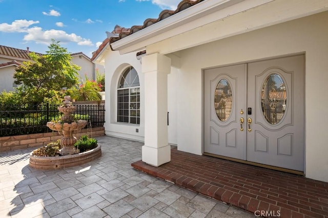 view of exterior entry with a patio