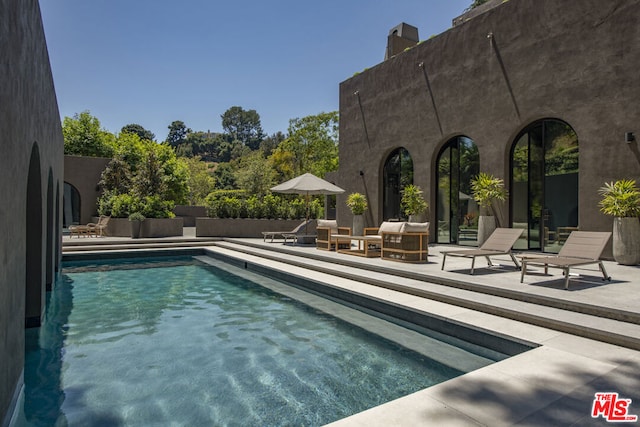 view of swimming pool featuring an outdoor living space and a patio