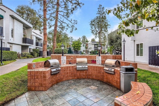 view of patio featuring exterior kitchen and a grill