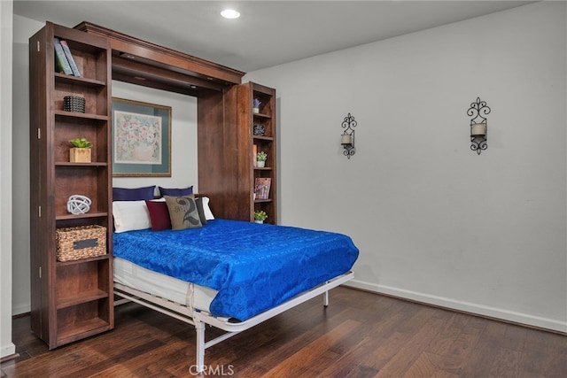 bedroom with dark hardwood / wood-style floors