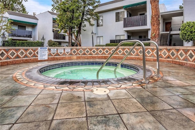 view of swimming pool with a hot tub