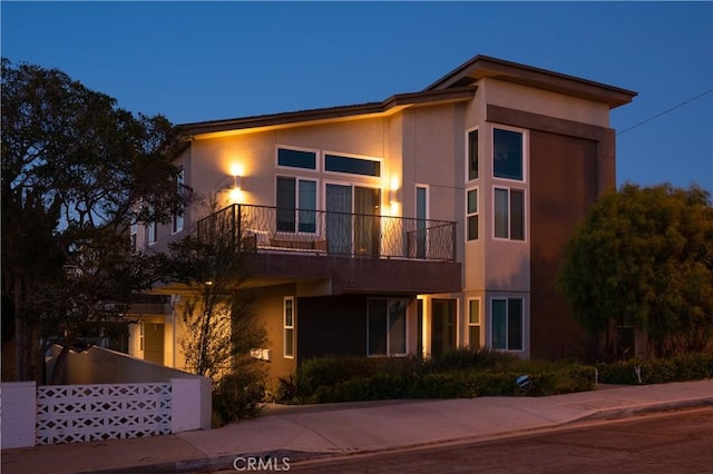 view of front of property with a balcony and concrete driveway