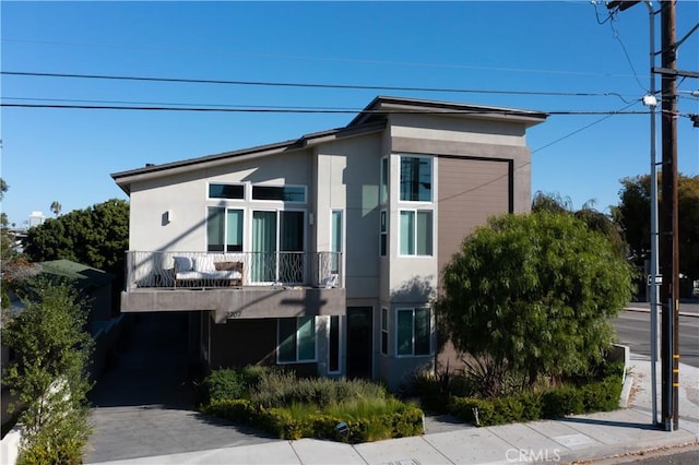 view of front of home with a balcony and stucco siding