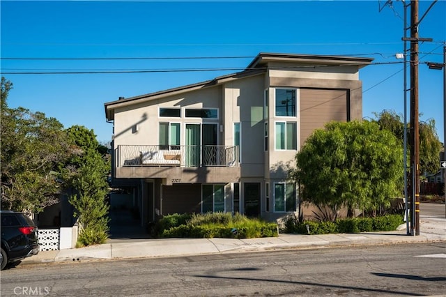 view of front facade with a balcony and stucco siding