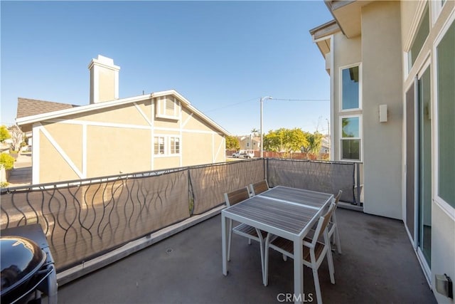 view of patio featuring a balcony and outdoor dining area