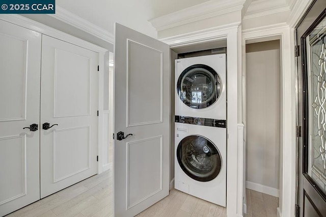 clothes washing area with crown molding, stacked washer / dryer, and light wood-type flooring