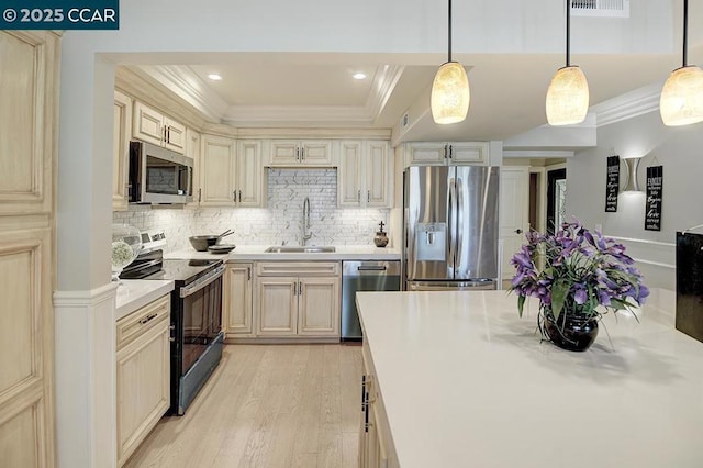 kitchen with pendant lighting, sink, crown molding, and appliances with stainless steel finishes