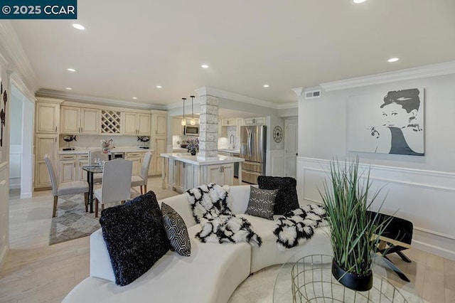 dining space with ornamental molding and light hardwood / wood-style floors