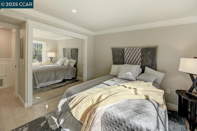 bedroom featuring ornamental molding, a closet, and light hardwood / wood-style flooring