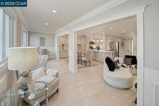 sitting room featuring crown molding and light hardwood / wood-style flooring