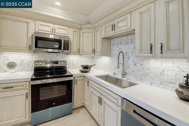 kitchen with crown molding, appliances with stainless steel finishes, sink, and decorative backsplash