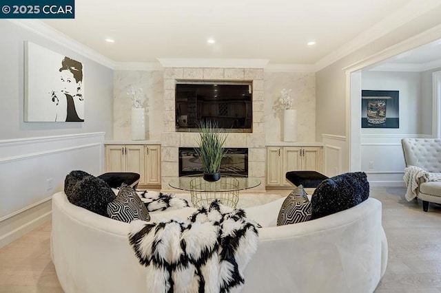 living room featuring a tile fireplace and crown molding