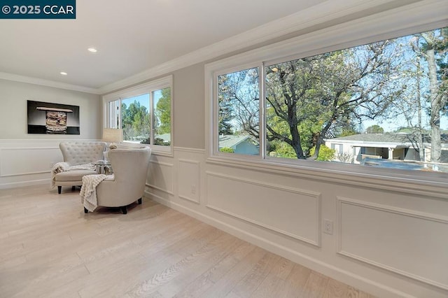 sitting room with crown molding and hardwood / wood-style flooring