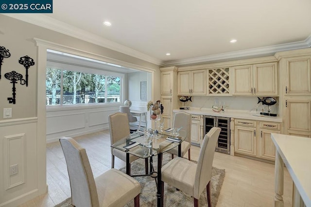 dining area with bar, crown molding, light hardwood / wood-style flooring, and beverage cooler