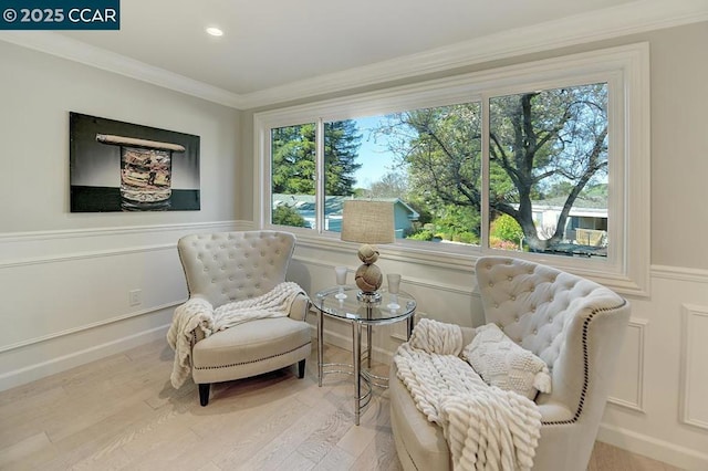 living area with hardwood / wood-style floors and ornamental molding