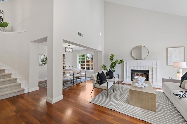 living room featuring a chandelier, a fireplace, and dark hardwood / wood-style flooring