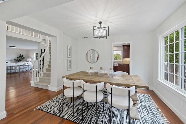 dining space featuring a notable chandelier, dark wood-type flooring, and plenty of natural light