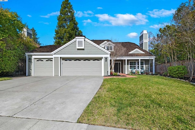 view of front of property featuring a garage, a front lawn, and covered porch