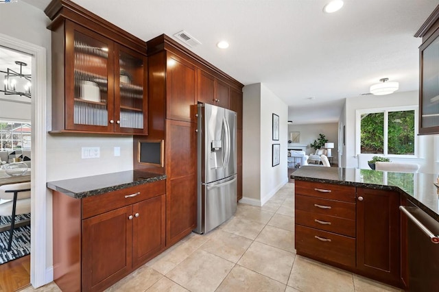 kitchen featuring light tile patterned flooring, dark stone counters, and stainless steel refrigerator with ice dispenser