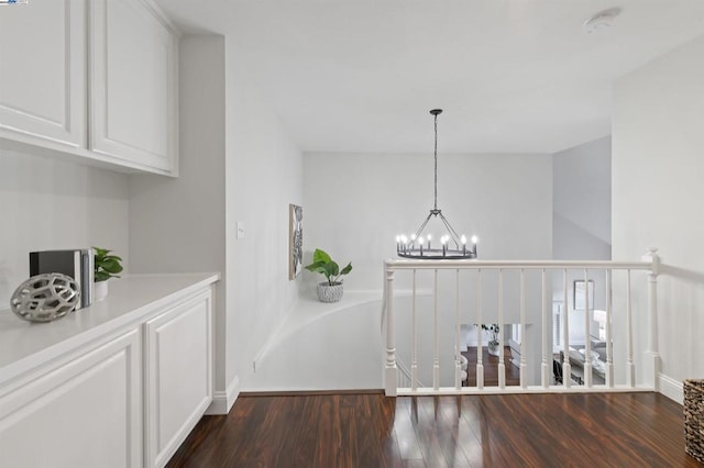 corridor featuring dark hardwood / wood-style floors and a notable chandelier