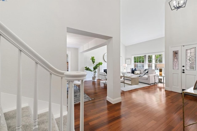 entrance foyer with dark wood-type flooring, a notable chandelier, and a high ceiling