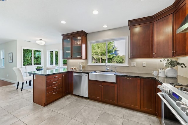 kitchen with dark stone countertops, appliances with stainless steel finishes, sink, and a wealth of natural light