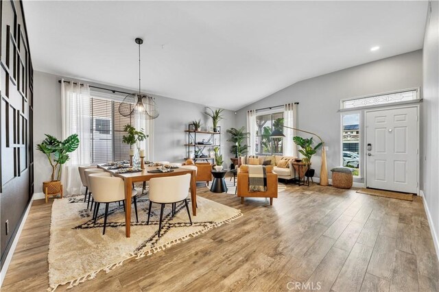 dining room featuring vaulted ceiling and light hardwood / wood-style floors