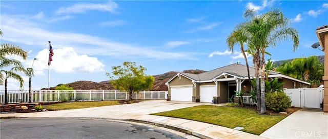 ranch-style home with a fenced front yard, a garage, concrete driveway, and a front lawn