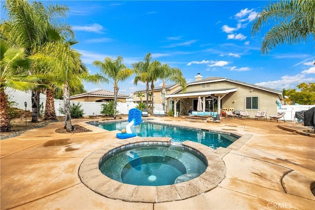 view of swimming pool with a fenced backyard, a pool with connected hot tub, and a patio