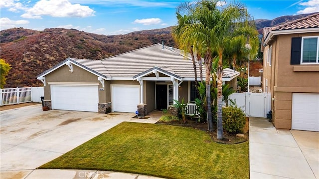 view of front facade featuring a mountain view, a garage, and a front lawn