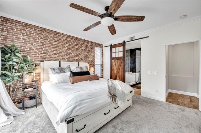 bedroom featuring light carpet, ornamental molding, ceiling fan, brick wall, and a barn door