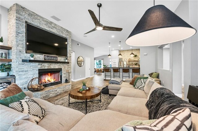 living room with hardwood / wood-style flooring, a fireplace, and ceiling fan