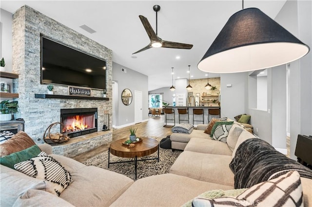 living room with wood finished floors, visible vents, a ceiling fan, recessed lighting, and a stone fireplace