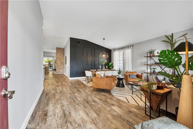 living room with plenty of natural light, hardwood / wood-style floors, and lofted ceiling