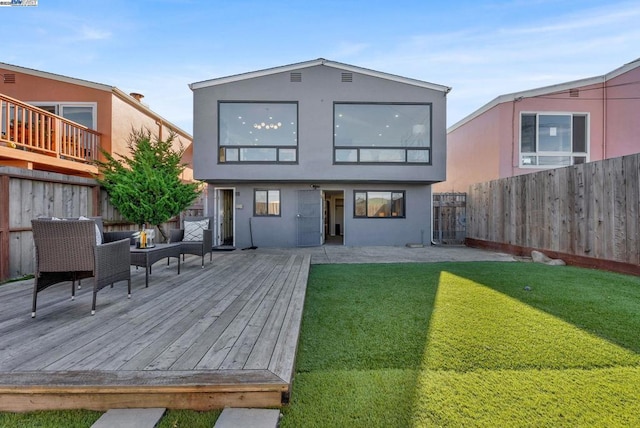 rear view of house featuring outdoor lounge area, a yard, a deck, and a patio area